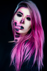 Halloween. Woman in day of the dead mask skull face art. Pink and black skull make up.
