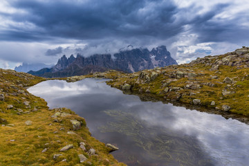 Obraz premium Clouds and mountain peaks reflection in the Dolomite Alps