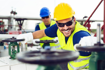 Oil worker closes the valve on the oil pipeline