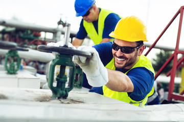 Oil worker closes the valve on the oil pipeline