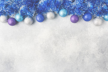 Blue Christmas balls and tinsel on grey background. New Year concept and scenery Copy space