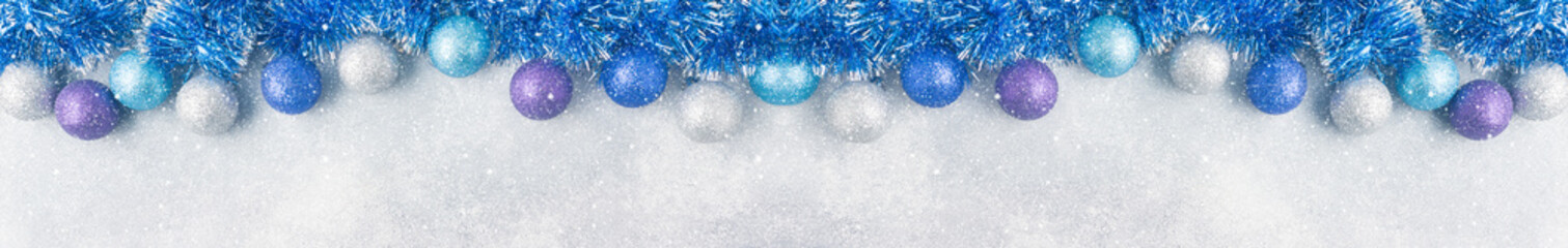 Blue Christmas balls and tinsel on grey background. New Year concept and scenery Banner