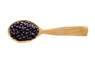 black barberry dried in wooden spoon isolated on white background. spice for cooking food, top view.