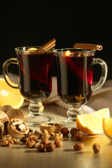 Two cups with ready mulled wine with anise, cinnamon and nuts around