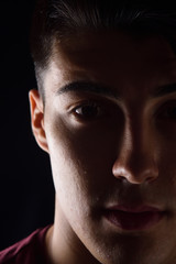 dark portrait of a young man on black background