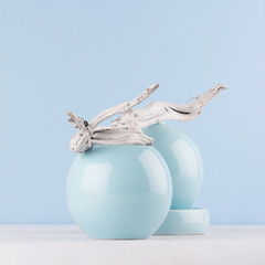 Obraz premium Home decoration in solt light pastel blue color - sphere shape vases and grey old twig on white wood background, square.
