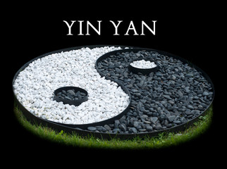 Sign of yin yang laid out of black and white stones isolated on black background. Ying Yang white text on black - obrazy, fototapety, plakaty