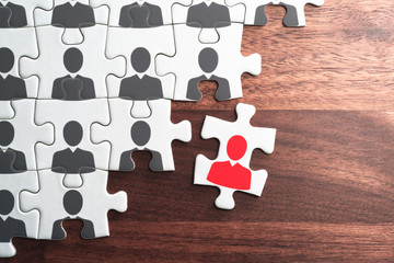 Human resource management. Creating successful organization.Personnel, employment and recruitment concept. Assembling jigsaw puzzle on wood desk.