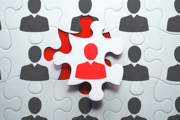 Selecting right people for organization's success. Think different and unique concept. Jigsaw puzzle piece with red businessperson standing out from the crowd.