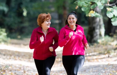 Photo sur Aluminium Jogging Mother and daughter wearing sportswear and running in forest