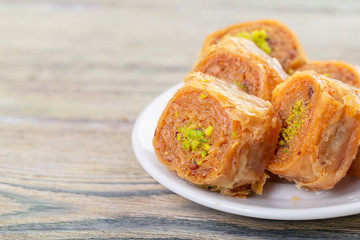 Traditional arabic dessert baklava with cashew, walnuts and cardamom with an eucalyptus branch on a wooden table