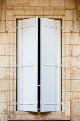 Old window with wooden white painted shutters