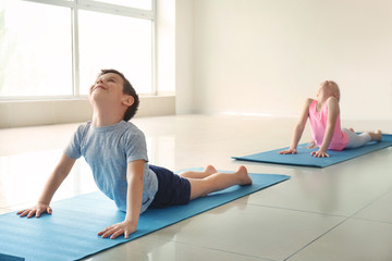 Little children practicing yoga indoors