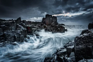 Foto auf Acrylglas Wasser Stimmungsvolle, dramatische Himmel und große Wellen stürzen auf Küstenfelsen