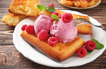 Delicious waffles with raspberries and ice cream on plate