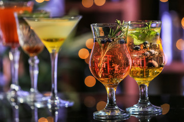Fresh summer cocktails in glasses on table against blurred lights