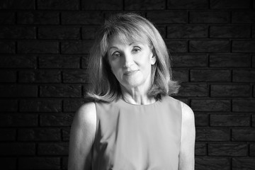 Black and white portrait of mature woman on dark background