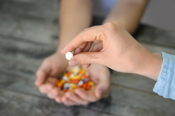 Woman holding pill, closeup