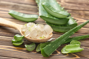 Spoon with aloe vera on wooden table