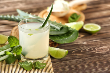 Glass of aloe vera juice on wooden table