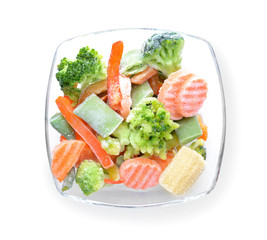Glass bowl with frozen vegetables on white background