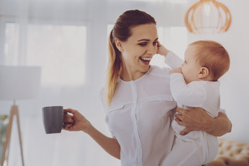 Lunch time. Prosperous influential businesswoman feeling happy laughing while coming home during...
