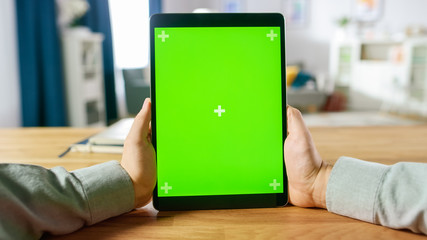 First Person Shot of Man Using Green Mock-up Screen Digital Tablet Computer in Portrait Mode while...
