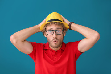 Handsome shocked man on color background