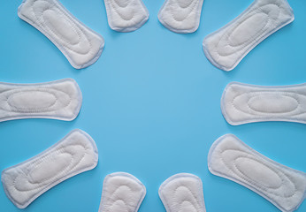 Frame made of menstrual pads on color background