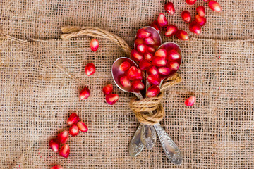 Pomegranate seeds, red, lie on a wooden vintage background