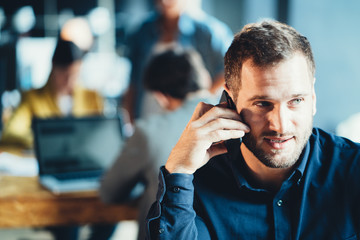Startup and millenial business concept. Portrait of young manager talking on the phone - obrazy, fototapety, plakaty
