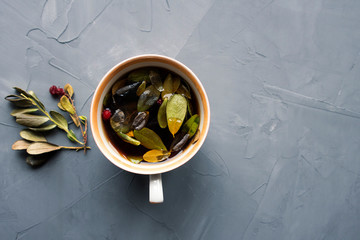 Lingonberry tea and leaves close-up on a gray background and copy space