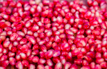 Pomegranate seeds, red, lie on a wooden vintage background