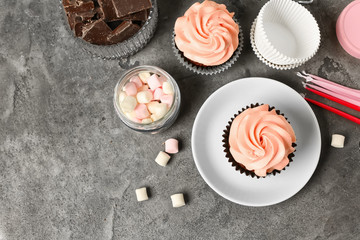 Composition with sweet cupcakes, chocolate and marshmallow on grey table