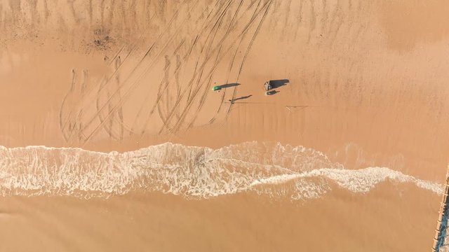 Aerial top down footage of two Fishermen on the beach casting off - Summer 2018 - Hornsea UK