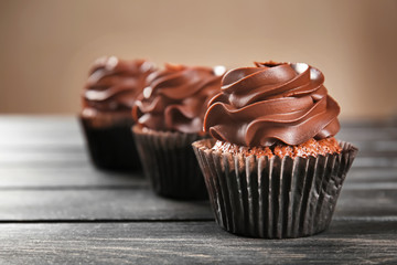 Delicious chocolate cupcakes on wooden table