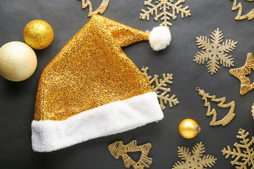 Golden Santa Claus hat with Christmas decorations on black background