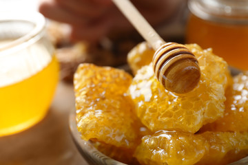 Wooden dipper and bowl with honeycomb, closeup