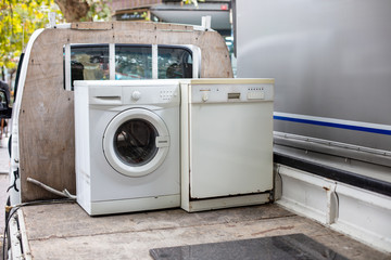 Old discarted dishwasher and washing machine on a vehicle  truck for recycling