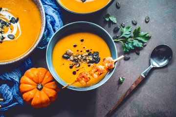 Roasted pumpkin and carrot soup with cream and pumpkin seeds 