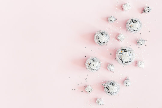 Christmas composition. Silver disco balls on pastel pink background. Christmas, winter, new year concept. Flat lay, top view, copy space