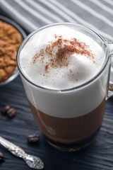 Glass cup of latte coffee on wooden table