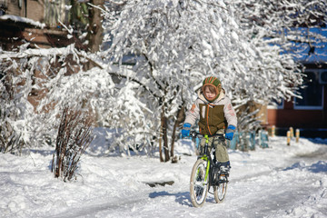 Naklejka premium Happy young guy riding bike on fresh snow