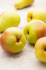 Fresh pears with leaves in a on wooden background.
