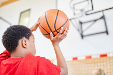 Junge mit dem Basketball in der Hand