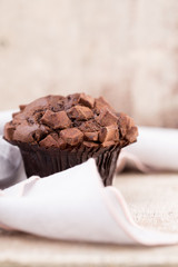 Homemade muffins with chocolate, vintage background.