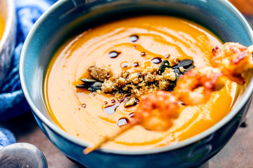 Roasted pumpkin and carrot soup with cream and pumpkin seeds 