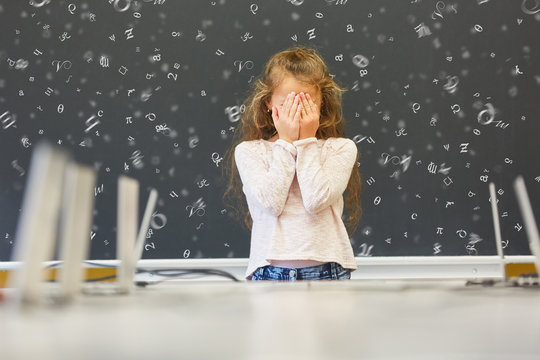 Kind mit Leseschw&auml;che in Schule vor Tafel