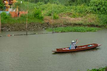 Woman rowing canal in the rain.