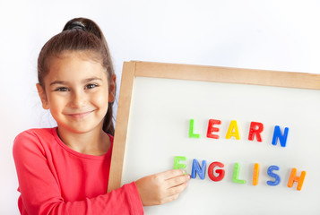 Language education concept. Learn English. Do you speak English. Cute little child girl with colored letters on the blackboard. English language school. English for children.